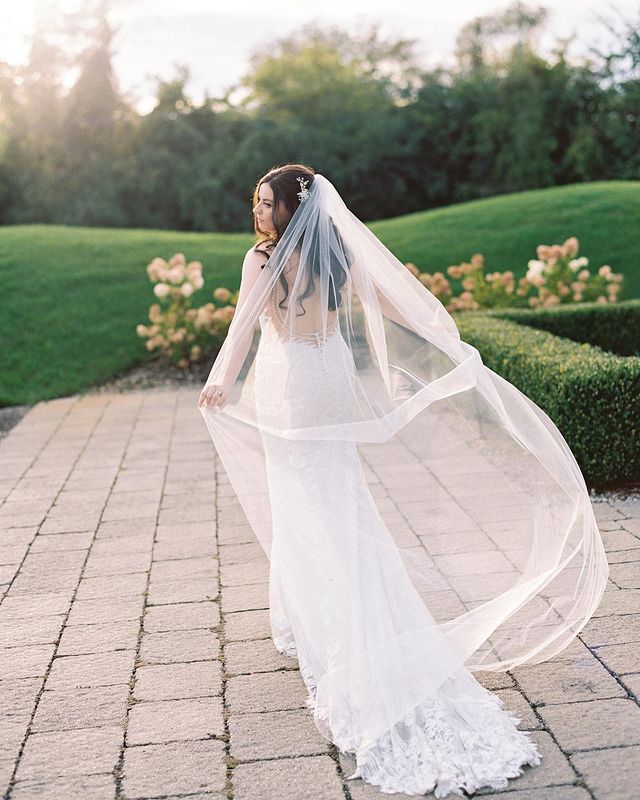 romantic bride poses beneath big tree ranch wedding venue